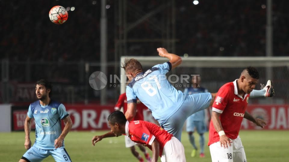 Pemain Persela Lamongan, Kristian Adelmund (tengah) berduel udara dengan Pemain Persija Jakarta, Ramdani Lestaluhu (kiri).